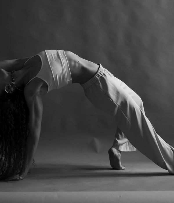 A woman in a graceful, flowing yoga pose, embodying balance and control.